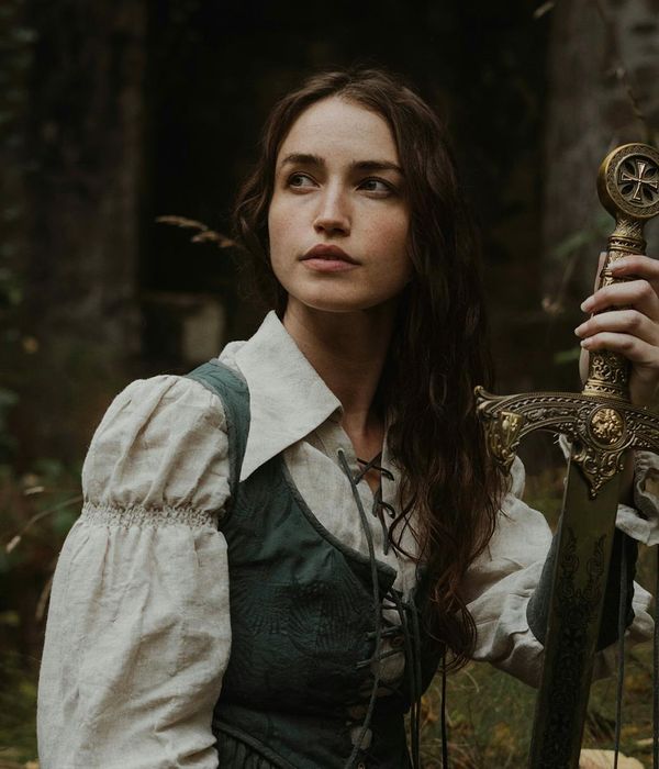 Person doing a warrior yoga pose against a dark background.